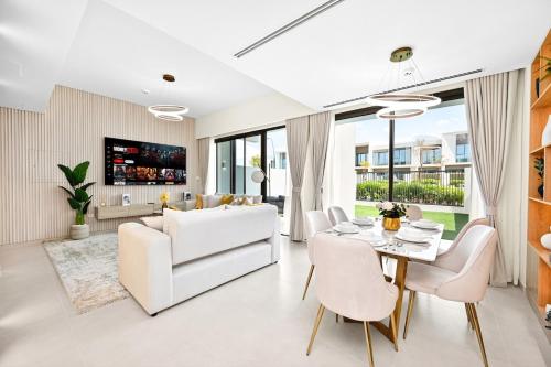 a living room with a white couch and a table at Golden Stays - Elegant 4BR Escape I Desert Light & Serene Views in Dubai