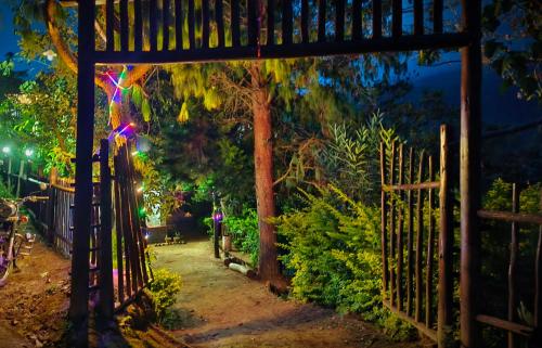 a gate leading to a garden at night at Madama Mudhouse Edenwood Retreats in Kanthalloor
