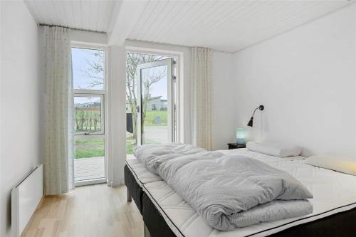 a white bedroom with a large bed and a window at 30609-Odder-Spovevej-1 in Odder