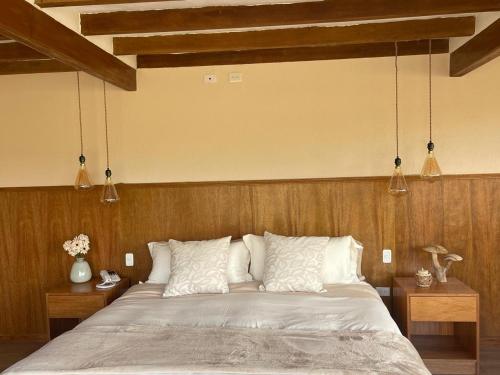 a bedroom with a large bed with wooden walls at Hotel Tambopaxi in Machachi