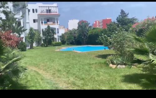 a large yard with a swimming pool in front of a building at residence Oum Kaltoum Oued Laou in Oued Laou
