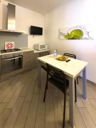 a kitchen with a table and chairs in a room at BelSorrisoVarese - Elegance City Residence Private Parking -Reservation Required- in Varese