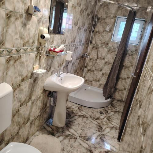 a bathroom with a sink and a shower and a toilet at Cazare Clara Cluj in Cluj-Napoca