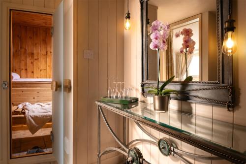 a bathroom with a glass counter with flowers on it at Dannah Farm Country House in Shottle