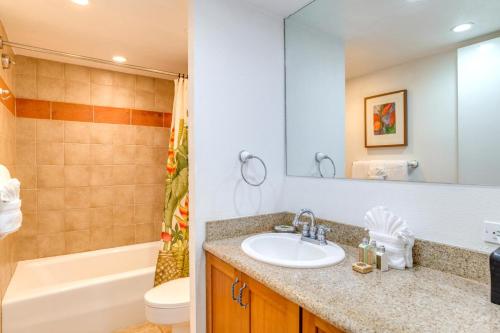 a bathroom with a sink and a tub and a toilet at Napili Point by KBM Resorts in Kaanapali