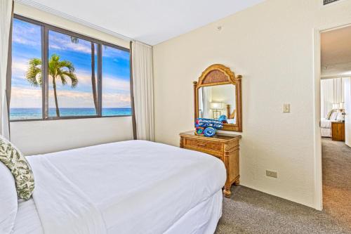 a bedroom with a bed and a mirror at Napili Point by KBM Resorts in Kaanapali