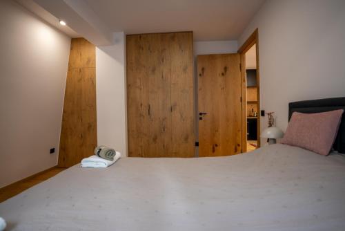 a bedroom with a large bed with wooden doors at Apartment Aveline in Bjelašnica