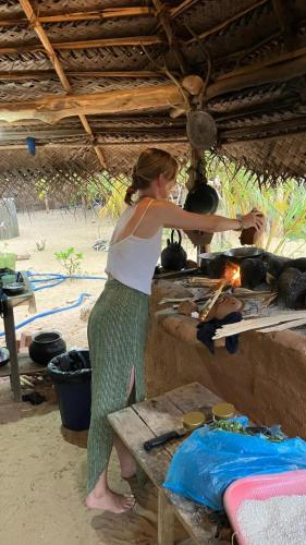 a woman standing on the beach with a stove at Secret Paradise Panama in Panama