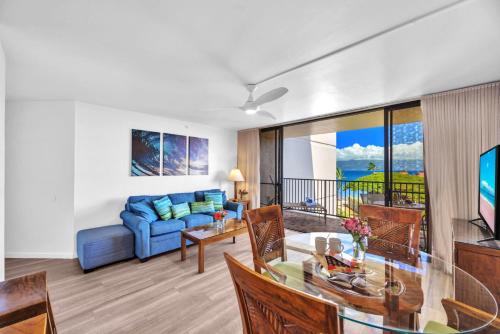a living room with a blue couch and a glass table at Napili Point by KBM Resorts in Kaanapali