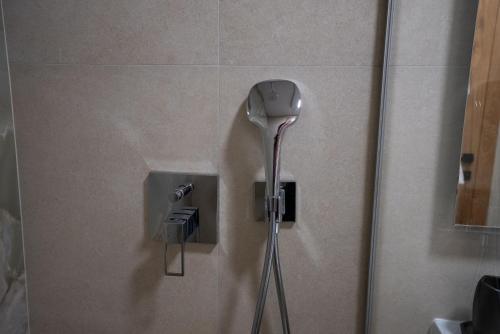 a shower in a bathroom with a shower head at Apartment Aveline in Bjelašnica