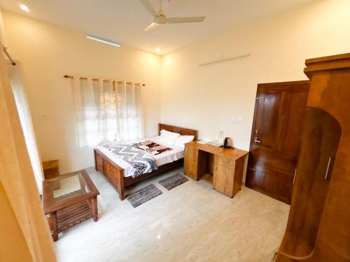 a bedroom with a bed and a table and a window at Nature View Home Stay in Vagamon