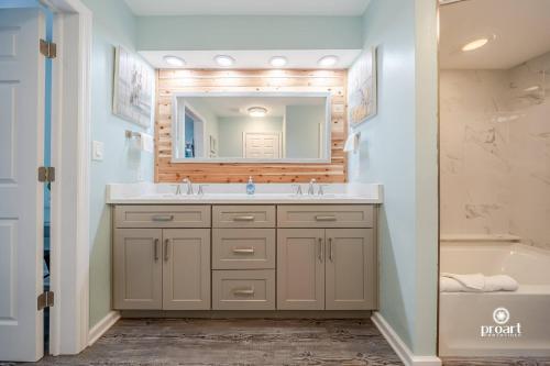 a bathroom with a sink and a mirror and a tub at Mermaid's Place* 0.6 miles to beach* monthly disc in Destin