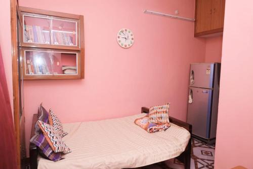 a small room with a small bed and a refrigerator at Pondy Brezze 2BHK Beach villa in Puducherry