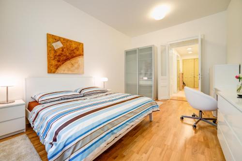 a bedroom with a bed and a desk and a chair at Bishop Apartments in Brno