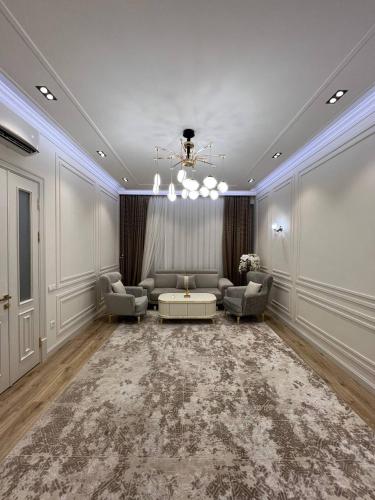 un salon avec un canapé, des chaises et une table dans l'établissement Tashkent City Apartments E2, à Tachkent