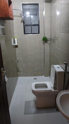 a bathroom with a toilet and a sink at Imani stay cations Diani in Diani Beach