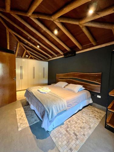 a bedroom with a large bed in a room with wooden ceilings at Casa Temporada de Luxo no Lago Campo Mourão in Campo Mourão