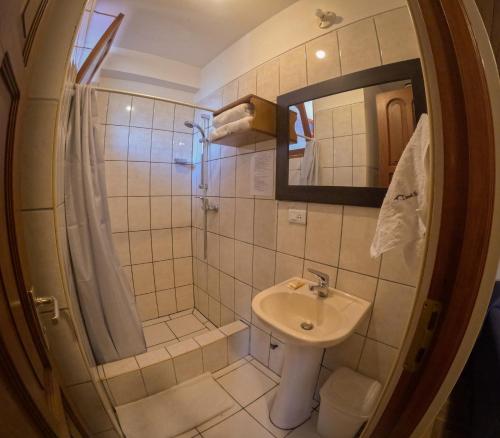 a small bathroom with a sink and a mirror at Rajutuna Inn in Huaraz
