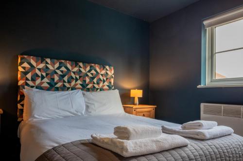 a bedroom with a bed with towels on it at 1 Hales Orchard in Worcester