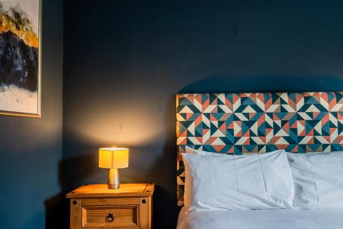 a bedroom with a bed and a lamp on a night stand at 1 Hales Orchard in Worcester