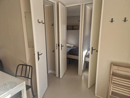 a hallway with two doors and a room with a bed at Camping les gorges de provences in Montagnac
