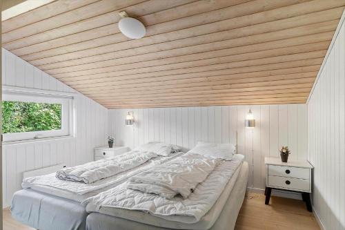 a bedroom with two beds and a wooden ceiling at 40571-Juelsminde-Pot-Strandby-116 in Sønderby