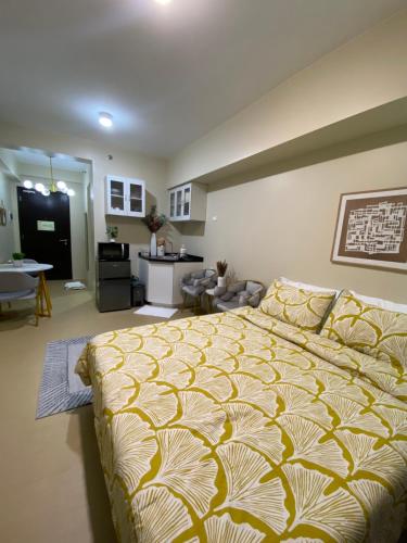 a bedroom with a large bed and a living room at AVIDA TOWERS - Aspira Tower1 in Cagayan de Oro