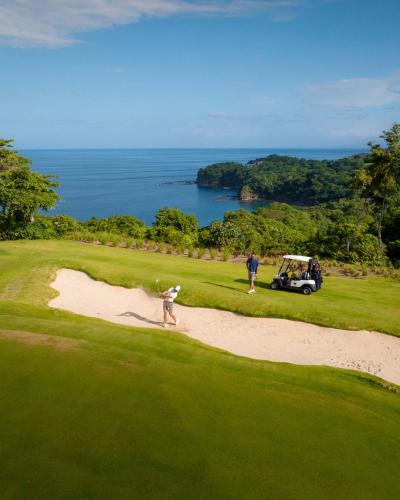 a group of people playing golf on a golf course at Villa Tortuga in Nacascolo