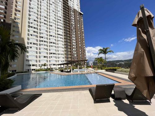 a swimming pool in front of a large building at AVIDA TOWERS - Aspira Tower1 in Cagayan de Oro