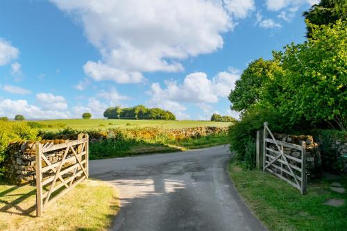 a country road with a gate and a field at Dannah Farm Country House in Shottle