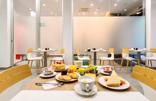 a table with plates of food on it at Hotel Emeté & Coworking by Airnest in Las Palmas de Gran Canaria