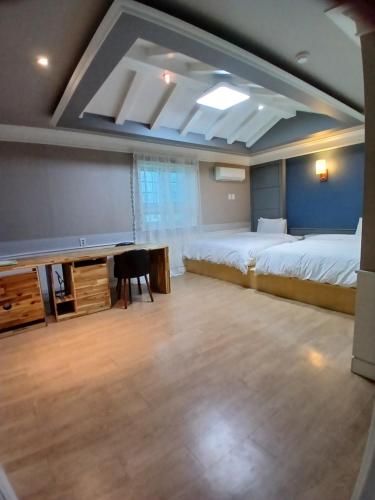 a large room with two beds and a desk in it at 히든힐불국사호텔 in Gyeongju