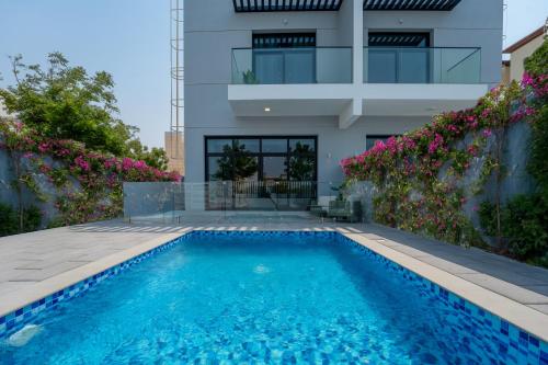 a swimming pool in front of a house at Private Pool Paradise Villa! Dubai Mall in a Flash! Complimentary Full Mid-Stay Refresh for 1 week stay in Dubai