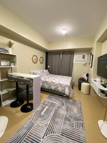 a bedroom with a bed and a desk and a tv at AVIDA TOWERS - Aspira Tower1 in Cagayan de Oro