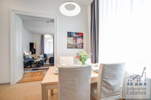 a dining room and living room with a table and chairs at Bishop Apartments in Brno