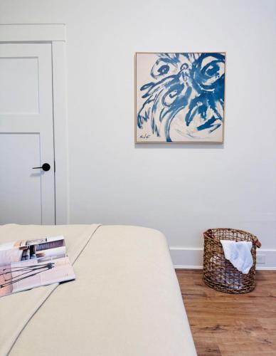 a bedroom with a bed with books and a picture on the wall at Deluxe Queen Room Private Ensuite Vancouver West in Vancouver