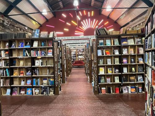 a book store aisle with shelves of books at Stunning Central Alnwick Two Floor Apartment in Alnwick