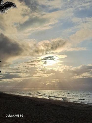 a beach with a cloudy sky and the ocean at Beach Bungalow 100 m Playa Coson in Las Terrenas