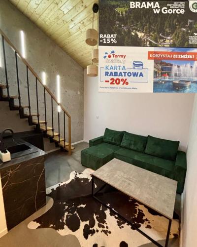 a living room with a green couch and a table at Noclegi u Wojtka in Sromowce Wyżne