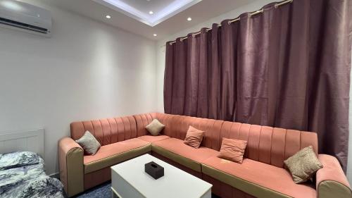 a living room with a couch and a table at Sumeras Sapphire Retreat in Ajman 