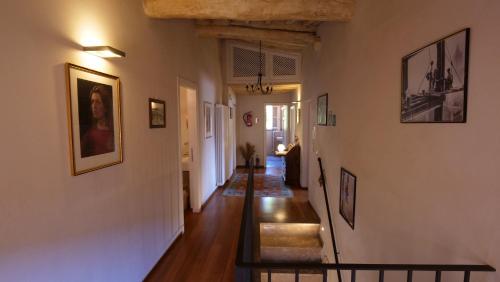 a hallway of a home with a staircase and paintings on the walls at da Francesco rooms in Lucca