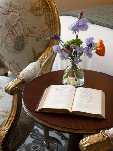 a vase of flowers and an open book on a table at Rosemead House in Victoria