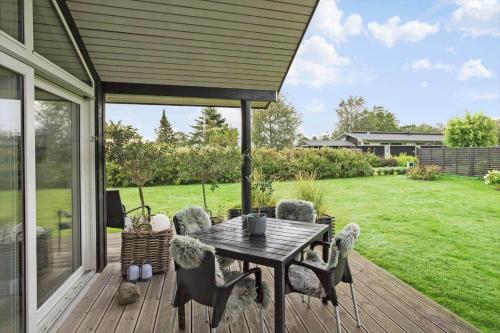 a patio with a table and chairs on a deck at 30178-Odder-Chr-Christensensvej-9 in Beder