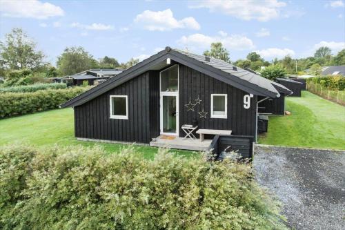 a black tiny house with a pitched roof at 30178-Odder-Chr-Christensensvej-9 in Beder