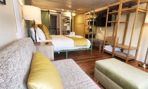 a bedroom with two beds and a couch in a room at Arbors at Island Landing Hotel & Suites in Pigeon Forge
