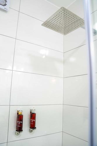 a white tiled bathroom with two fire hydrants at Mamasara Machupicchu in Machu Picchu