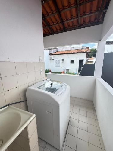 a bathroom with a washing machine and a tub at Otima casa bem localizaca para 6 a 8 pessoas in São Luís