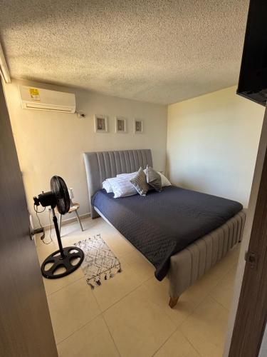 a small bedroom with a bed and a fan at Corazón de quilla in Barranquilla