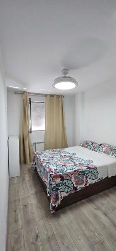 a bedroom with a bed with a quilt on it at Ático con Terraza Feria Albacete in Albacete