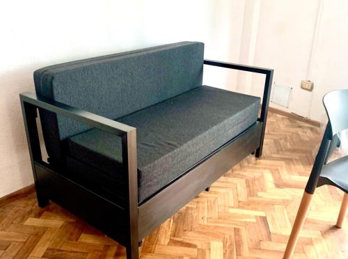 a bed with a black frame on a wooden floor at Departamento Moreno in Rosario